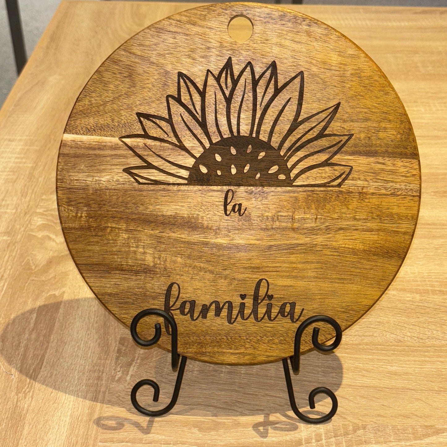 Wooden wall art with floral design and 'family' text in a store setting