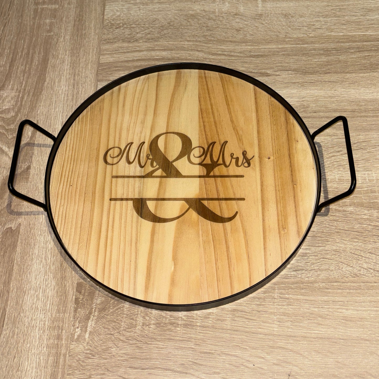 Wooden round cutting board with engraved 'Mr & Mrs' on a wooden surface