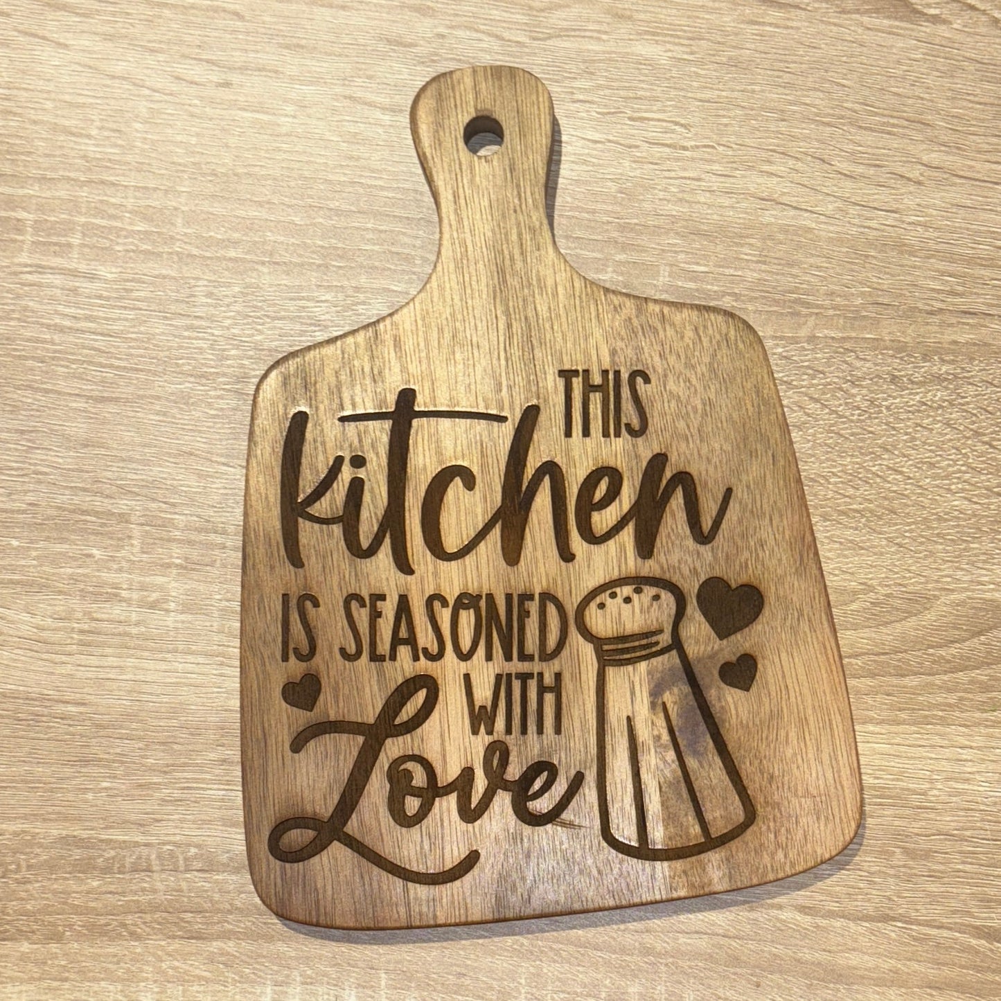 Wooden cutting board with engraved text on a wooden surface