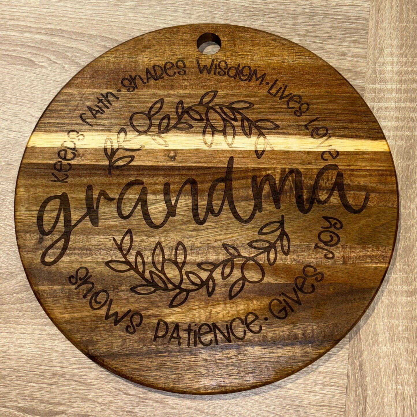 Wooden round sign with engraved text on a wooden surface