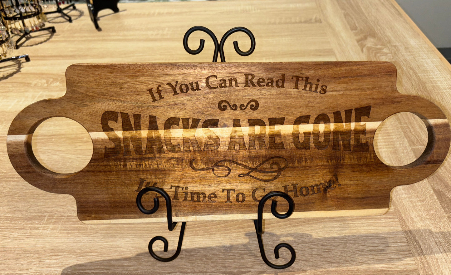 Wooden snack tray with engraved text on a wooden surface