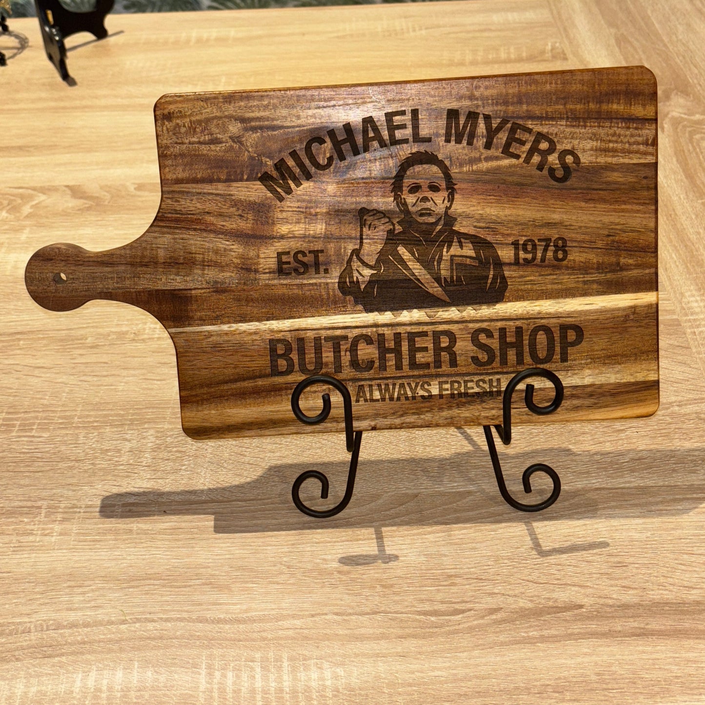 Wooden cutting board with engraved text on a wooden surface