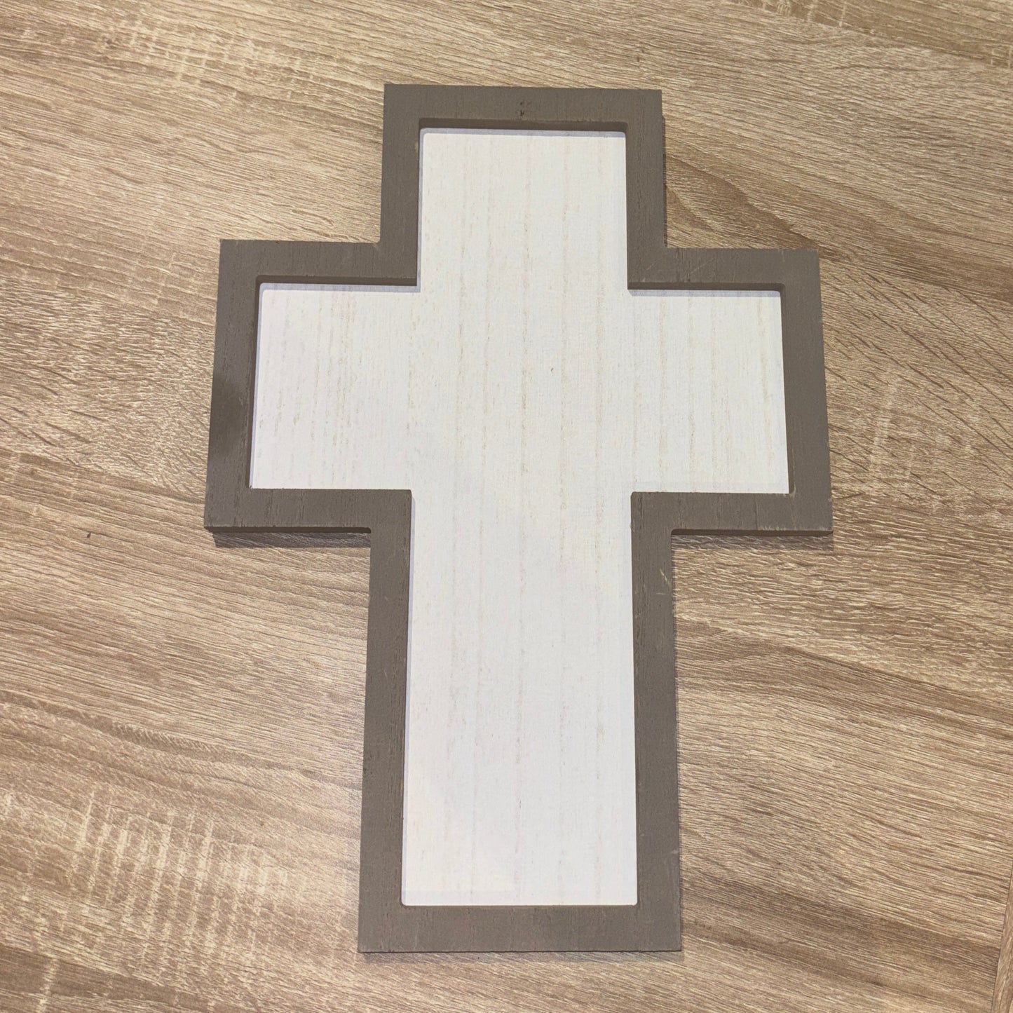Wooden surface with a white cross on a gray border