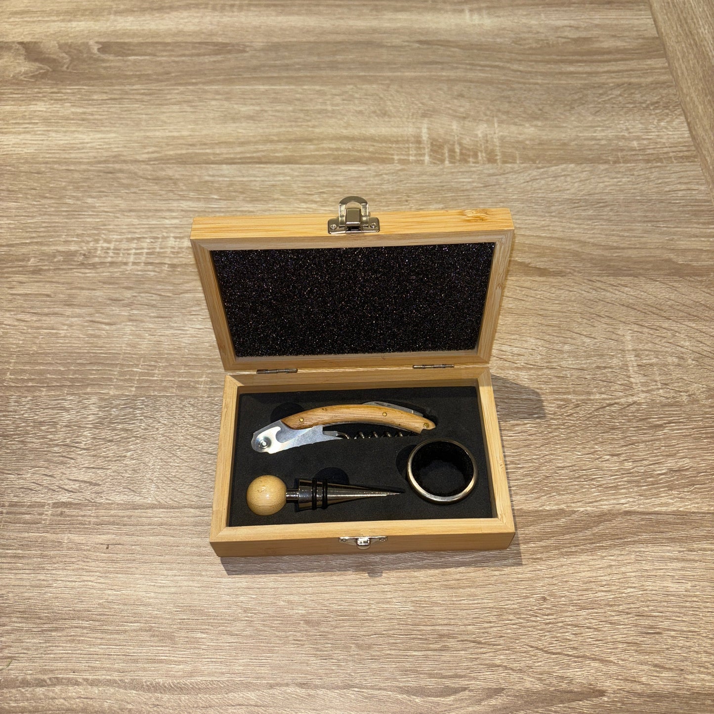Wine accessory set in a wooden box on a wooden surface