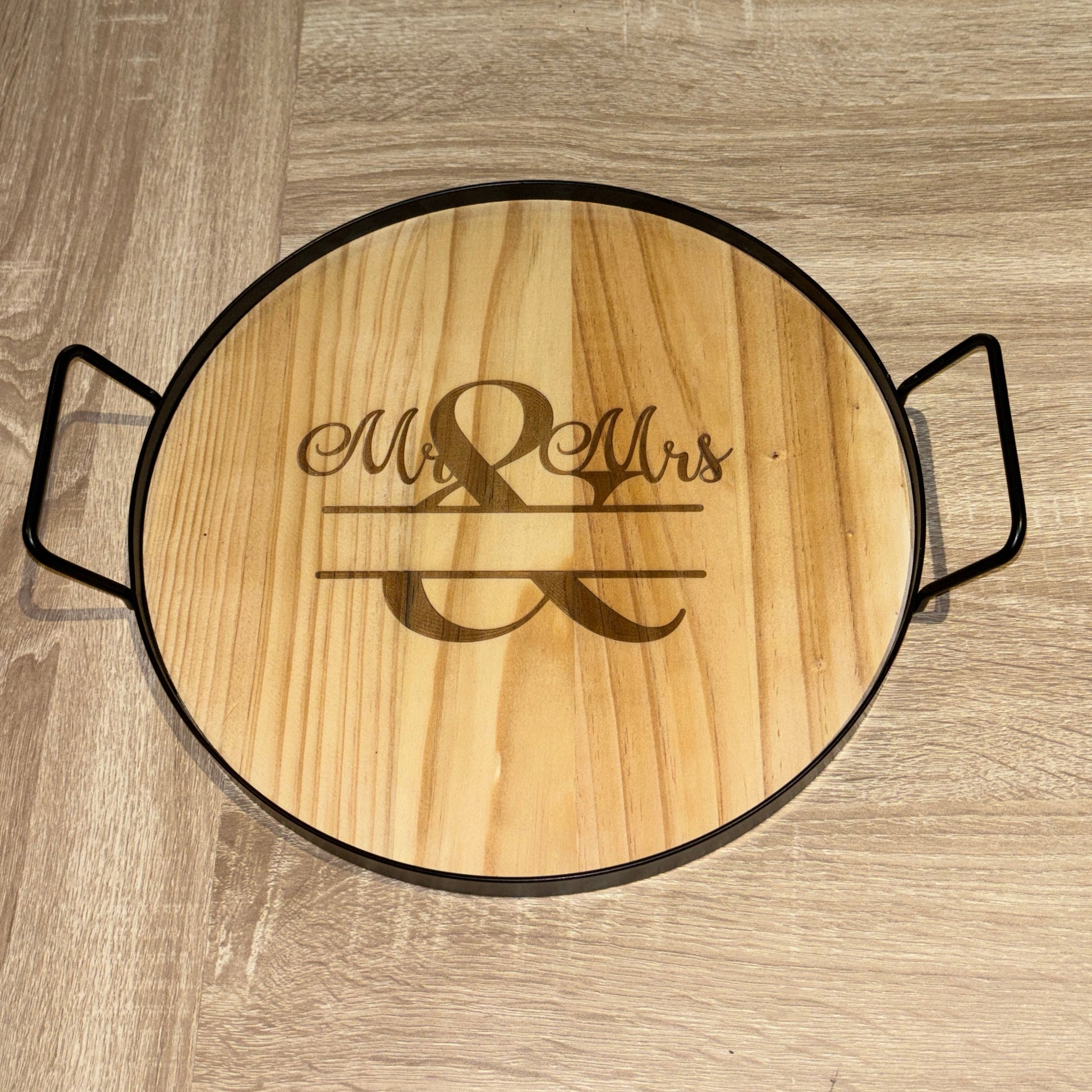 Wooden round cutting board with engraved 'Mr & Mrs' on a wooden surface