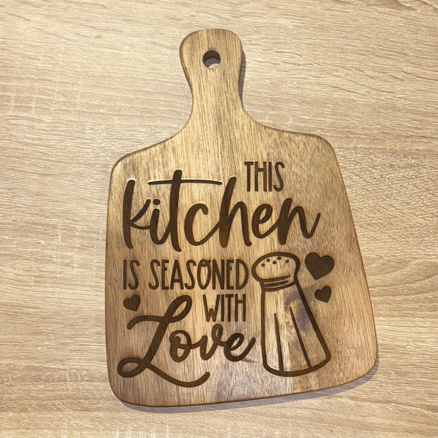 Wooden cutting board with engraved text on a wooden surface