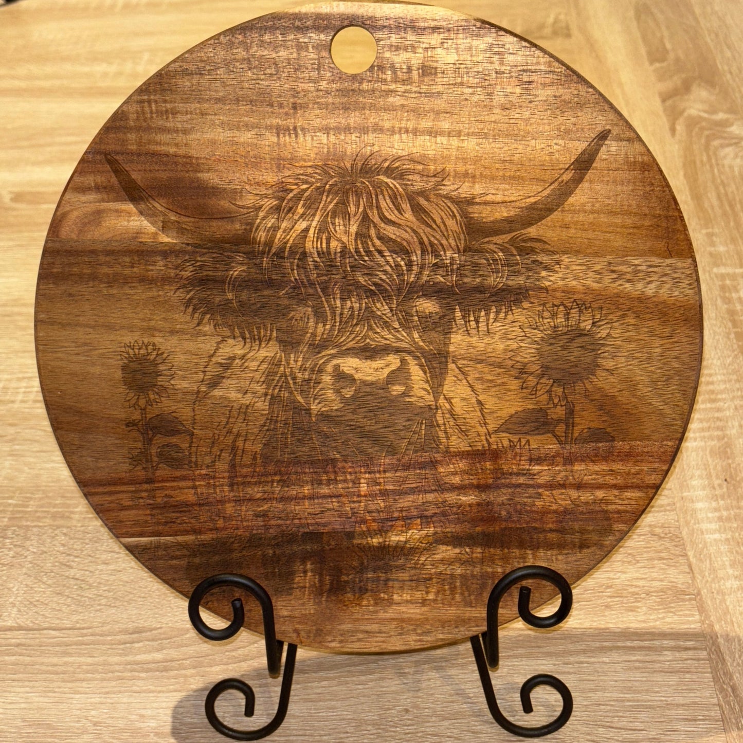 Wooden cutting board with engraved design on a wooden surface