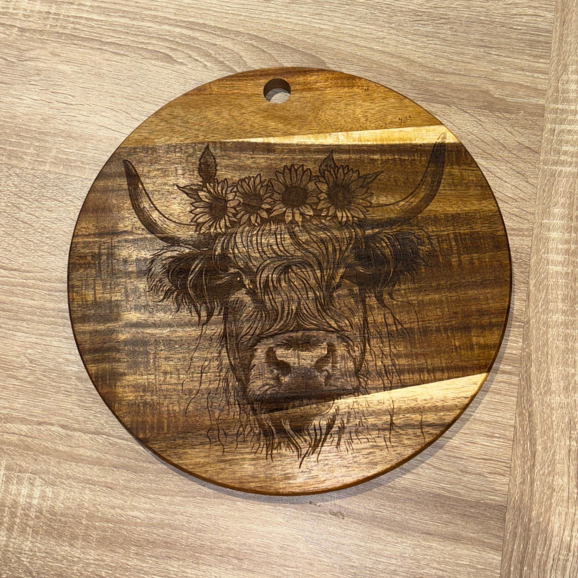 Wooden surface with a circular cutout featuring an engraved design.