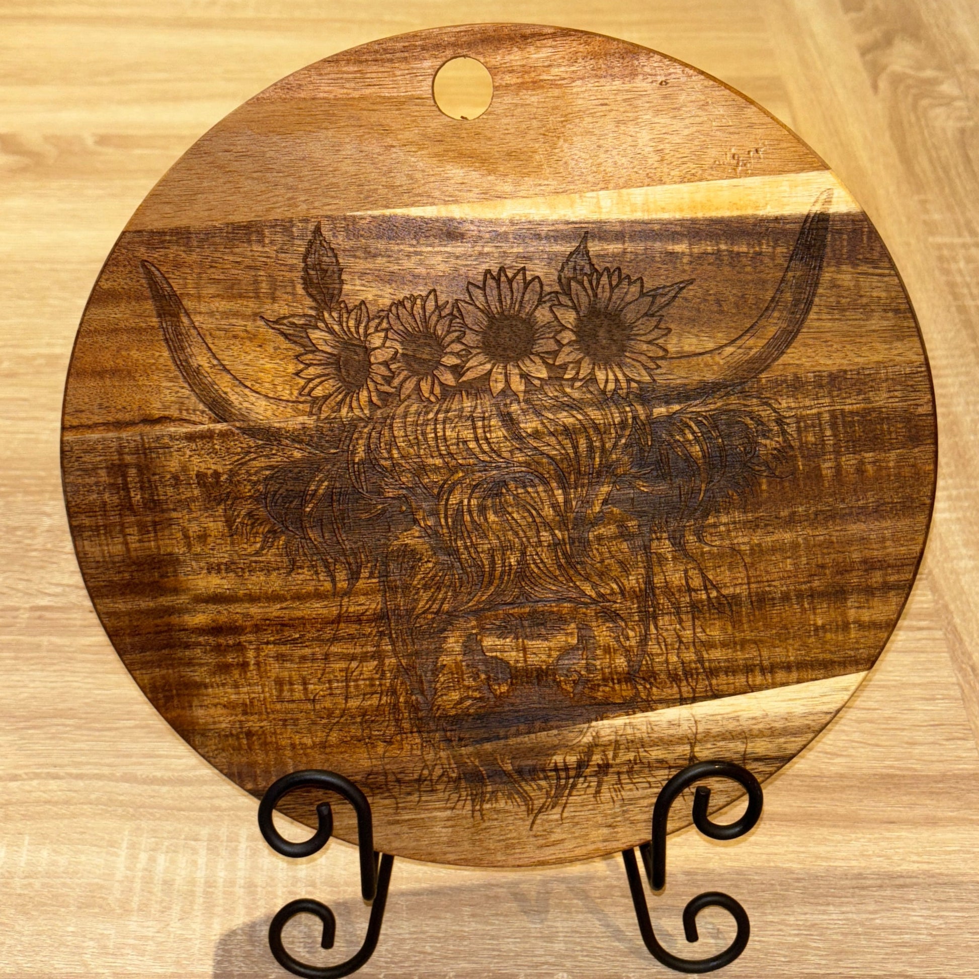Wooden cutting board with floral design on a wooden surface