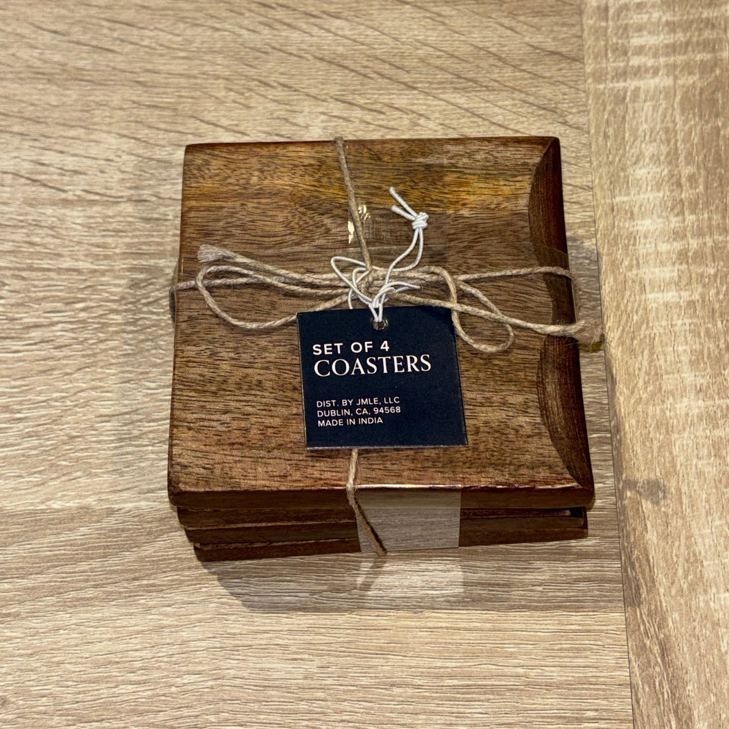Set of wooden coasters with a tag on a wooden surface