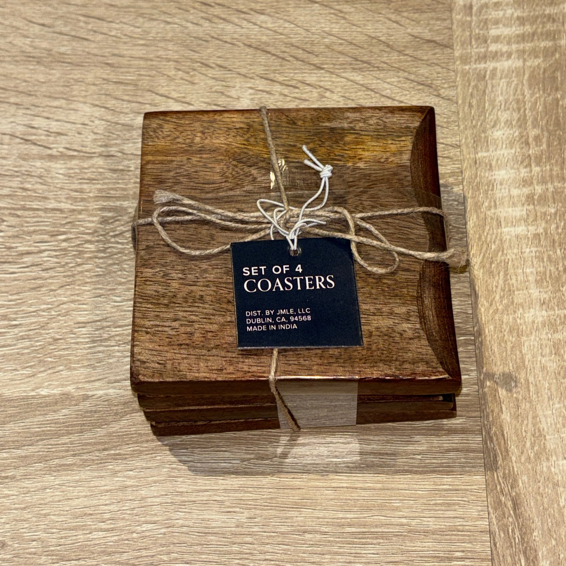 Set of wooden coasters with a tag on a wooden surface